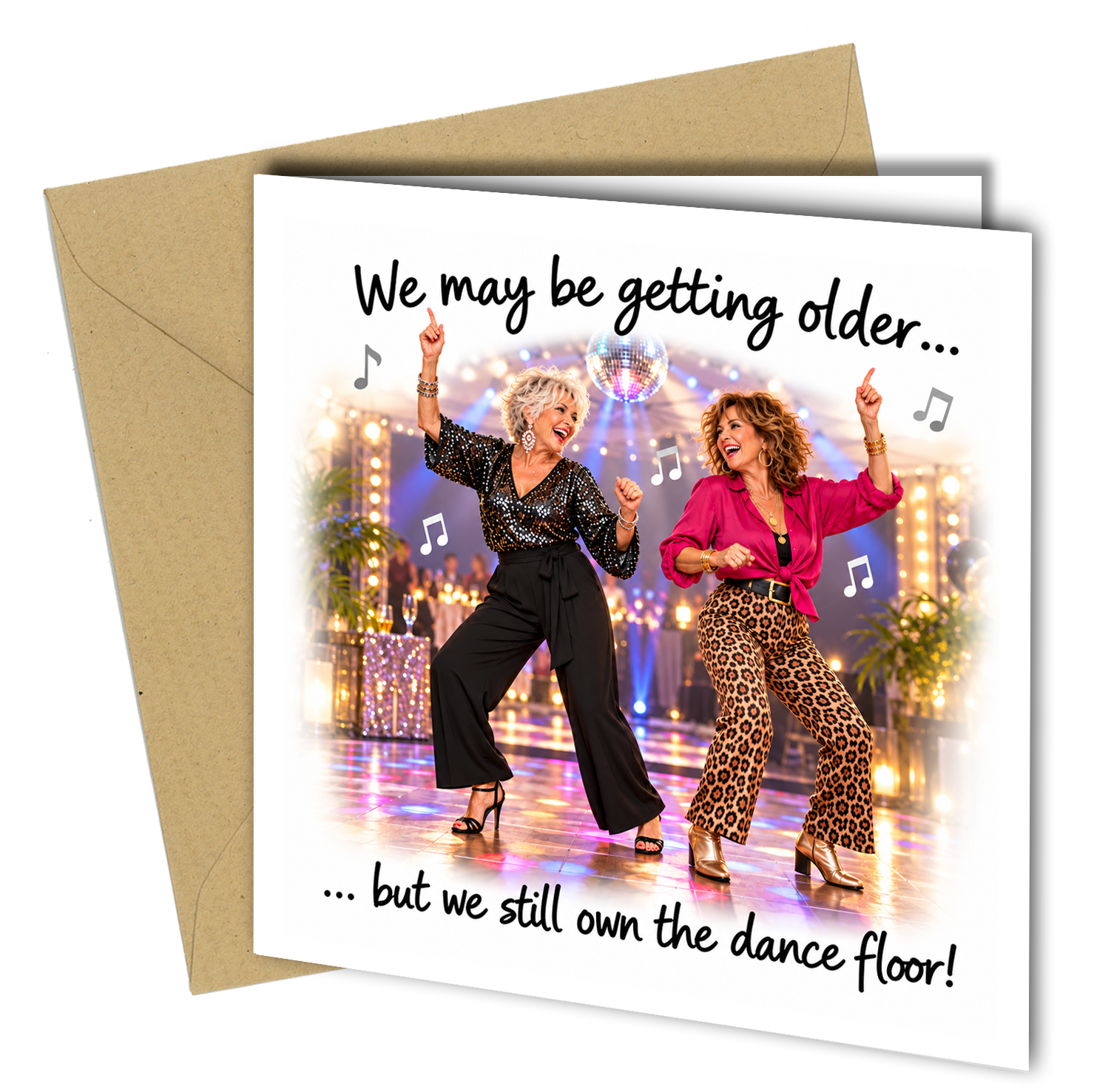 A square greeting card with a kraft envelope behind it, featuring a printed photo of two women dancing on a disco floor with the text 'We may be getting older.