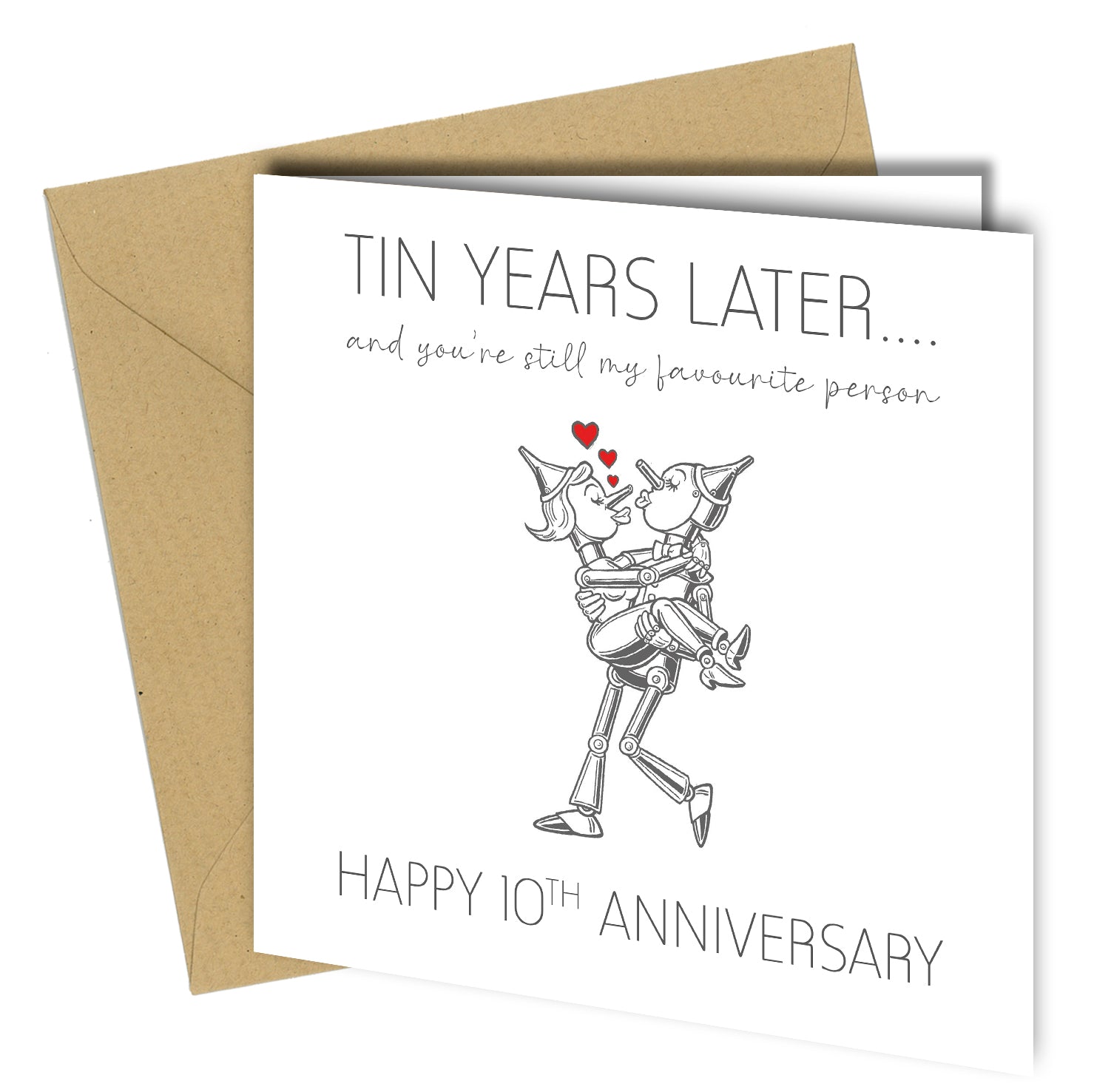 "Wife smiling while opening a ‘Tin Years Later… Happy 10th Anniversary’ card featuring two tin characters hugging, with her husband sitting beside her on a sofa."
